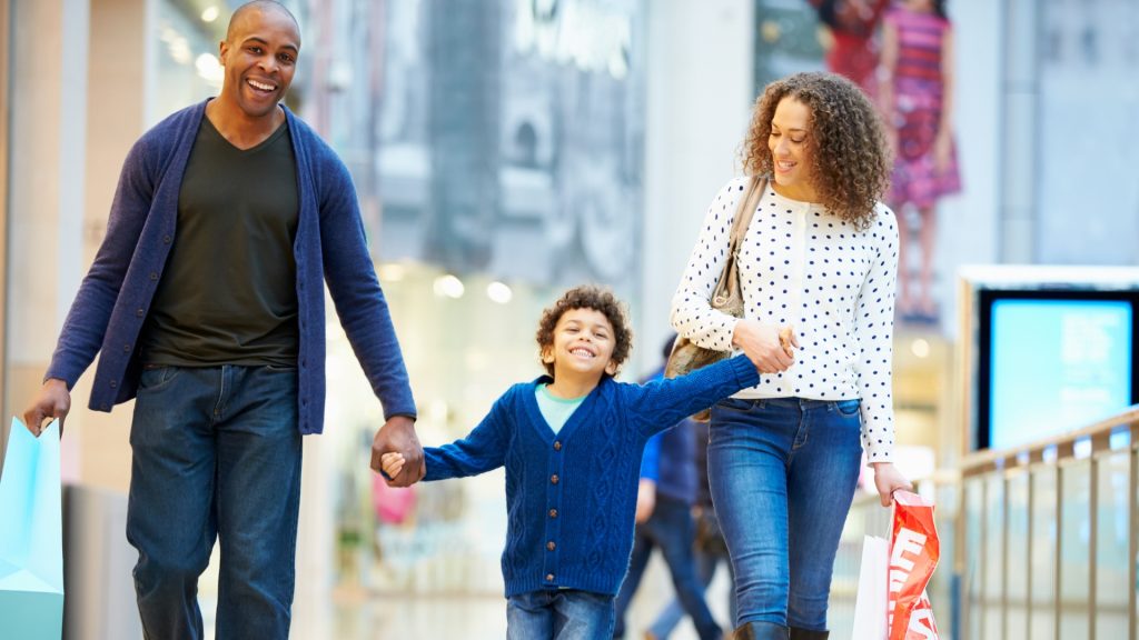 Happy Black family including mom, dad, and son shopping