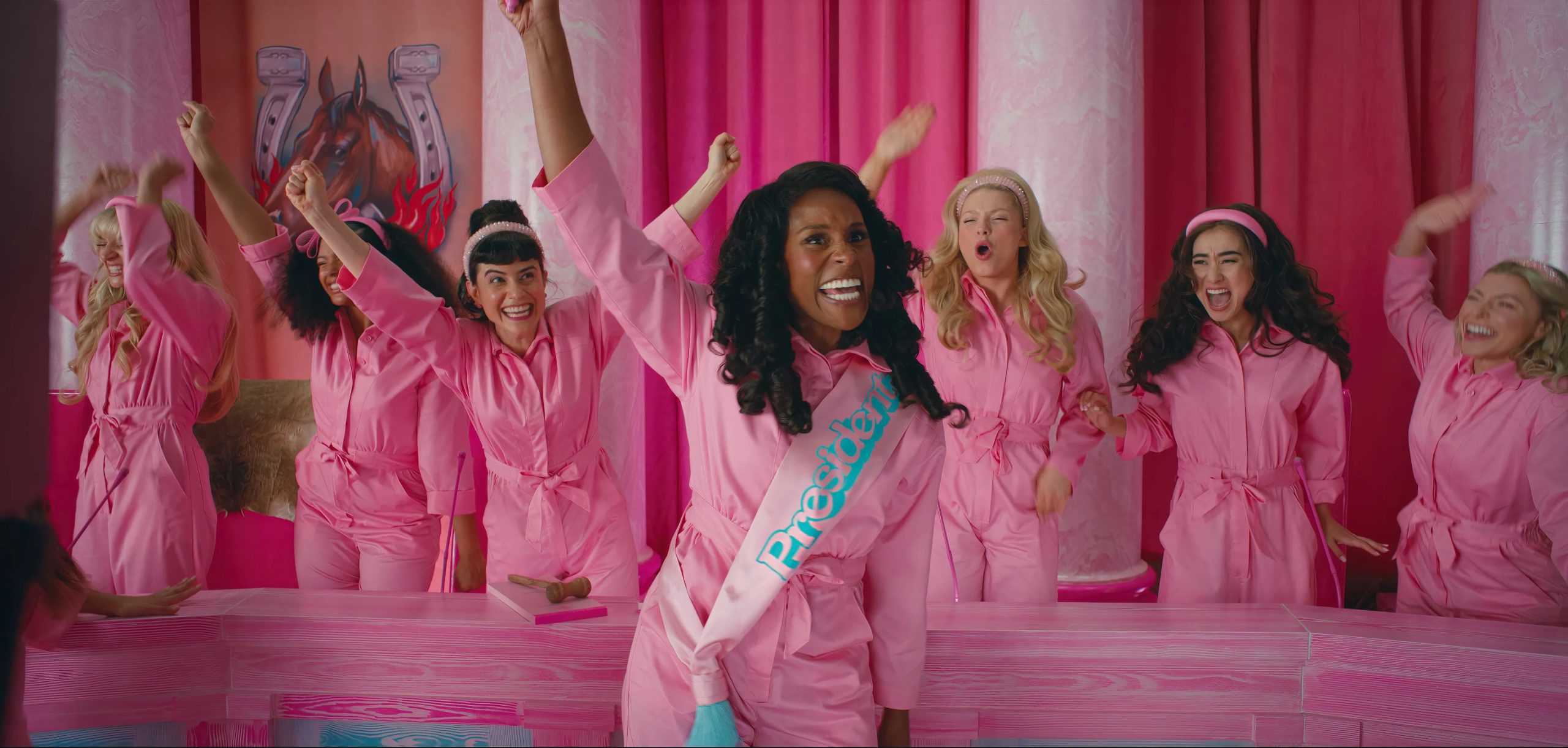 A still shot of Issa Rae as "President Barbie" alongside other cast members of the Barbie movie