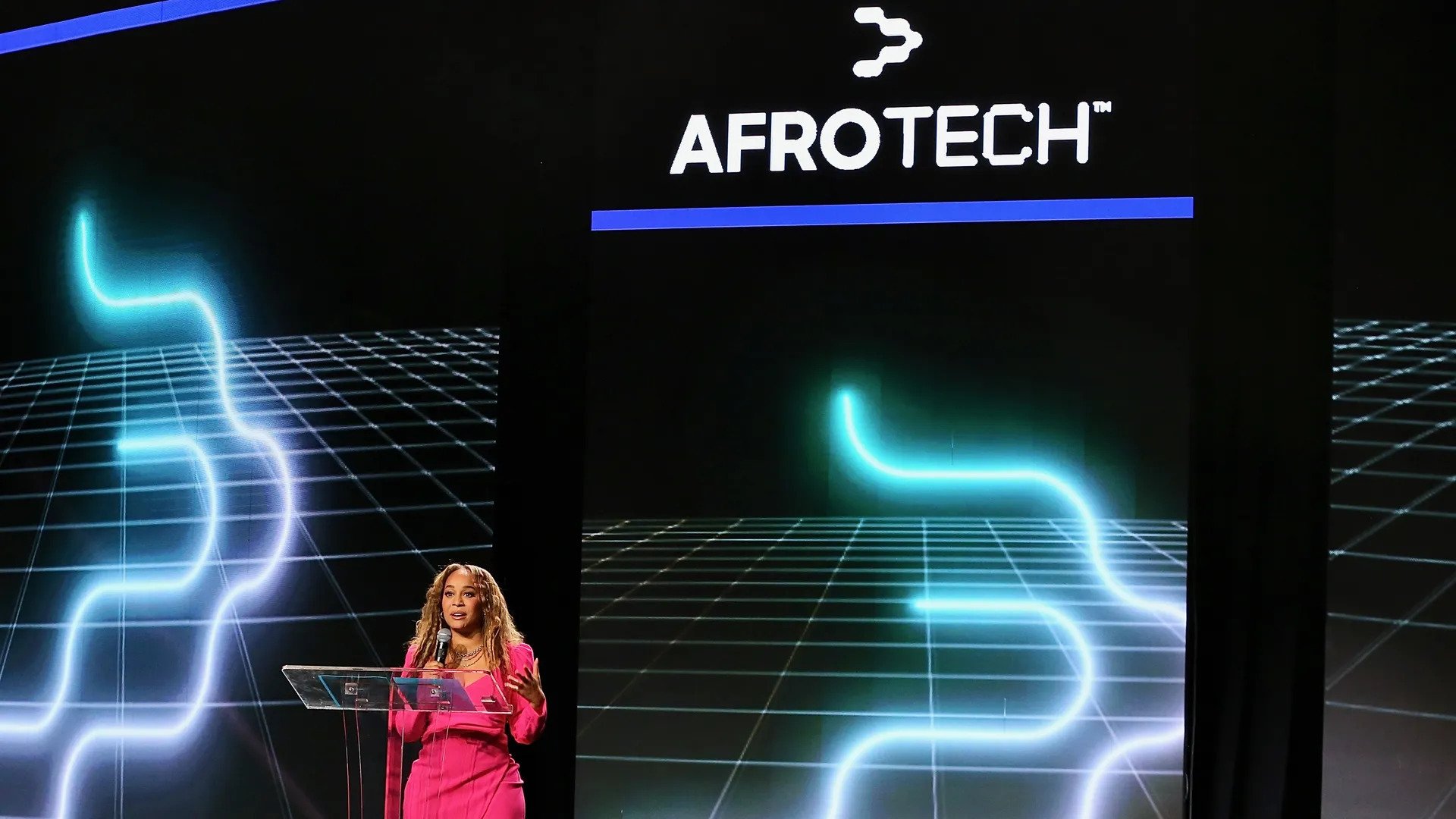 Blavity Inc. founder Morgan DeBaun standing on stage at the AfroTech conference wearing a pink dress