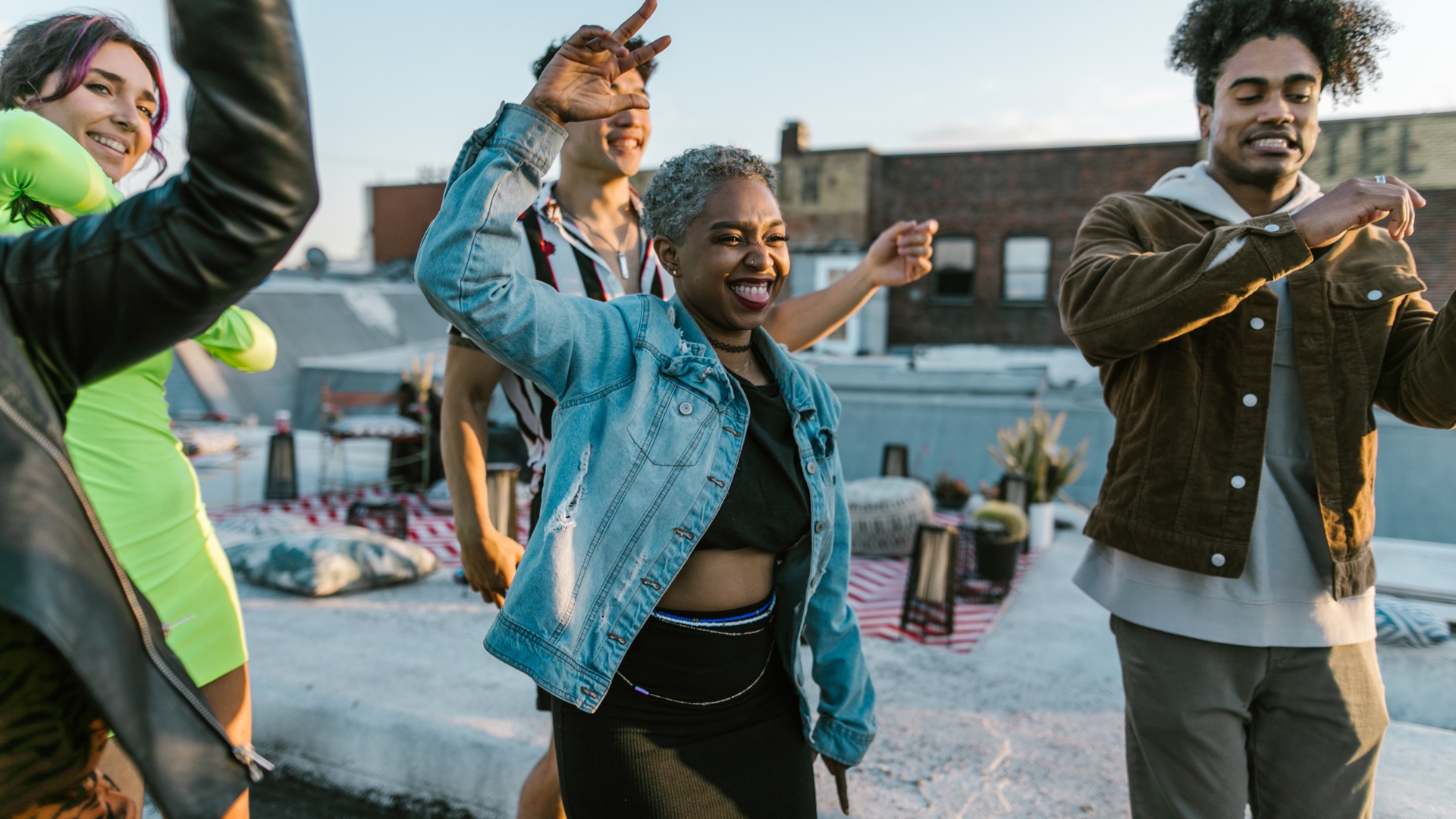 A group of vibrant multicultural millennials having fun at an exclusive rooftop dance party through a company's effective audience building