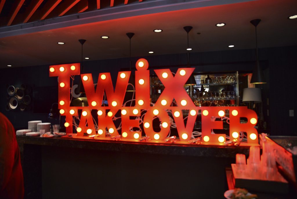 A vibrant photo of the Twix Takeover lighting fixture at the Twix x AfroTech sponsorship event