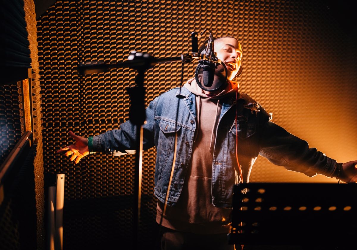 Black male music artist in the studio booth creating content that will drive social media engagement