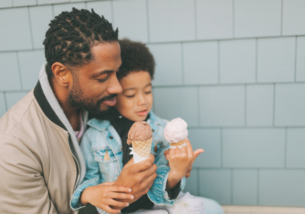 Black father featured in inclusive marketing campaign with his son holding 2 ice cream cones