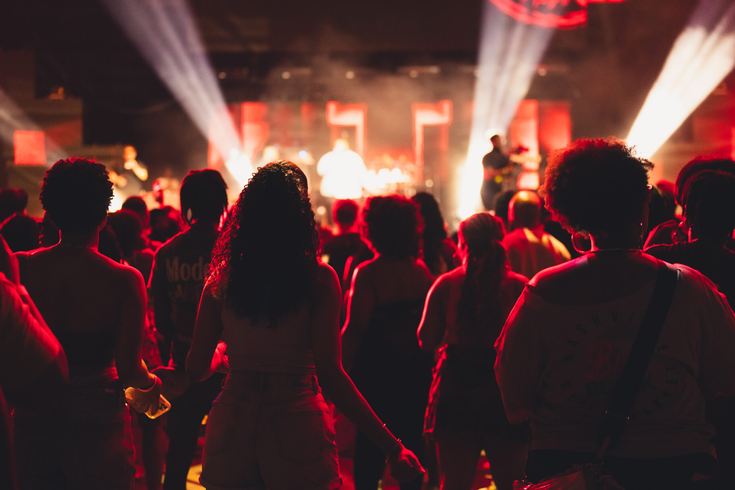 Blavity House Party attendees stand in the audience enjoying a great night of music