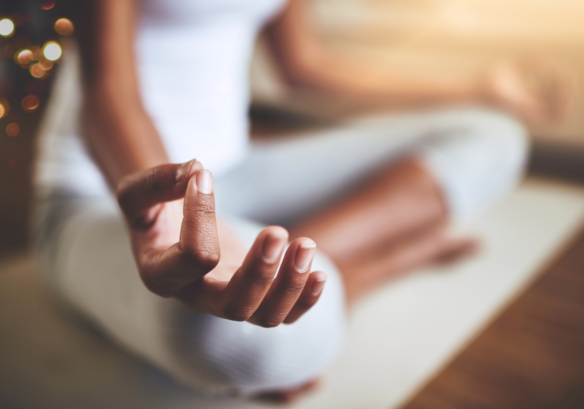 A woman of color celebrating a positive company culture while meditating