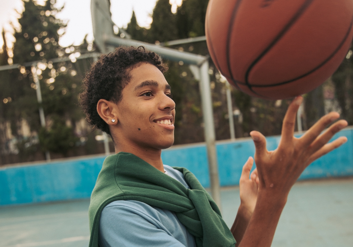 Gen Alpha teen male playing with basketball sold to him through an effective back to school ecommerce strategy