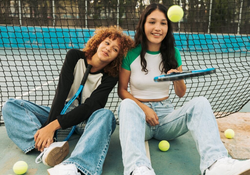 Two Gen Alpha teen girls play with tennis balls sold to them through an effective back to school ecommerce strategy